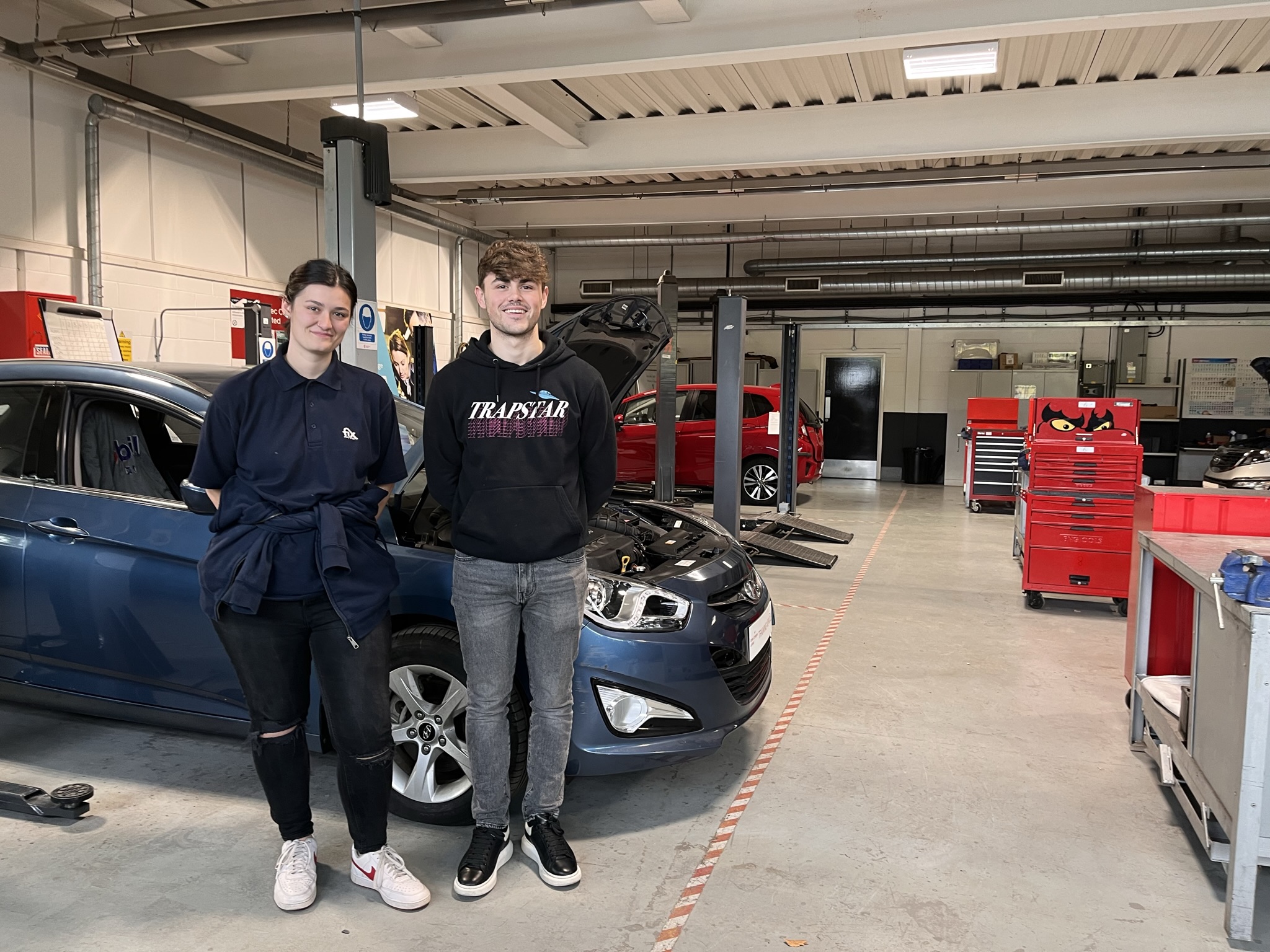 2 students in a Automotive workshop.