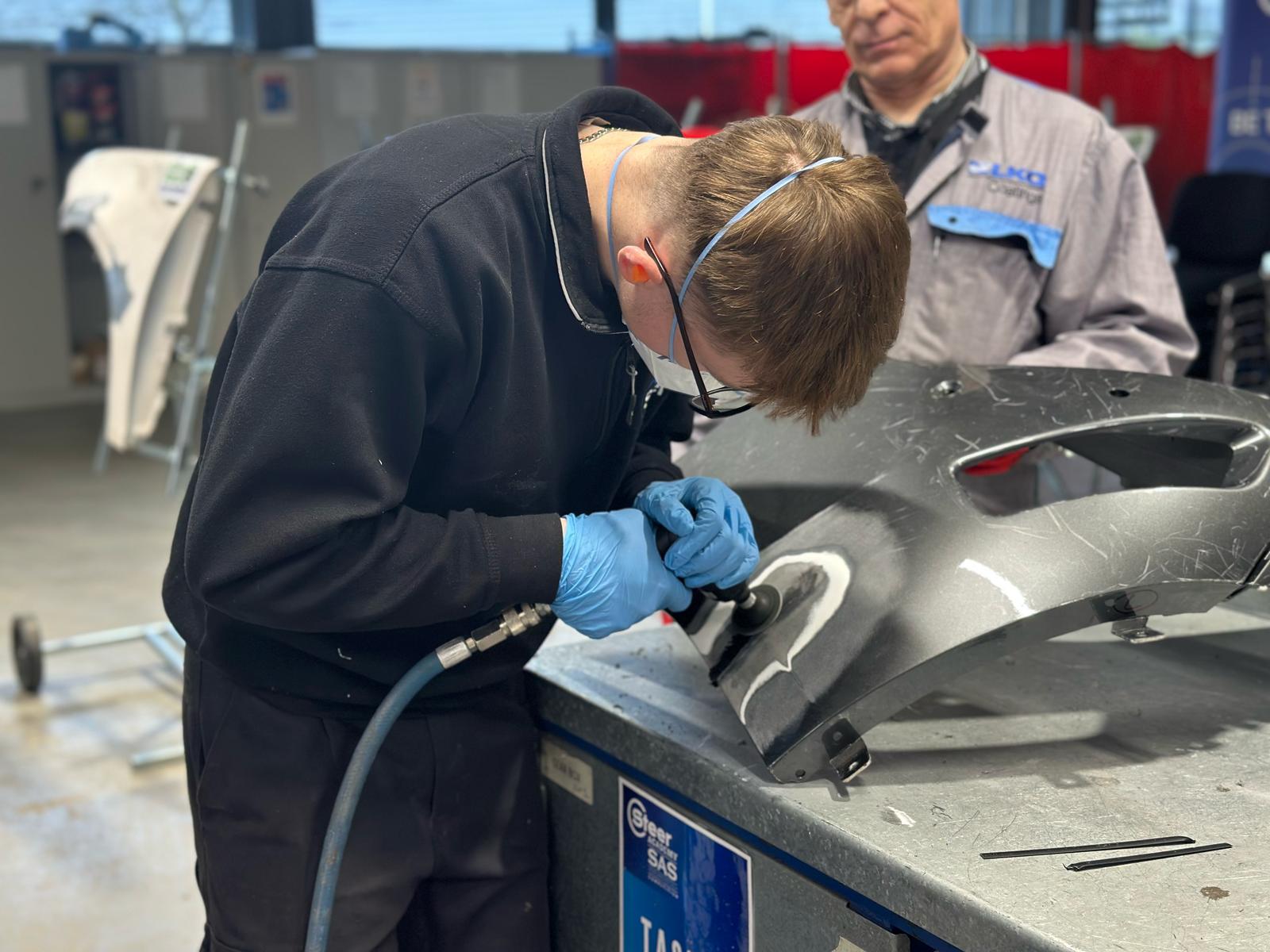 Male student working on a car body part