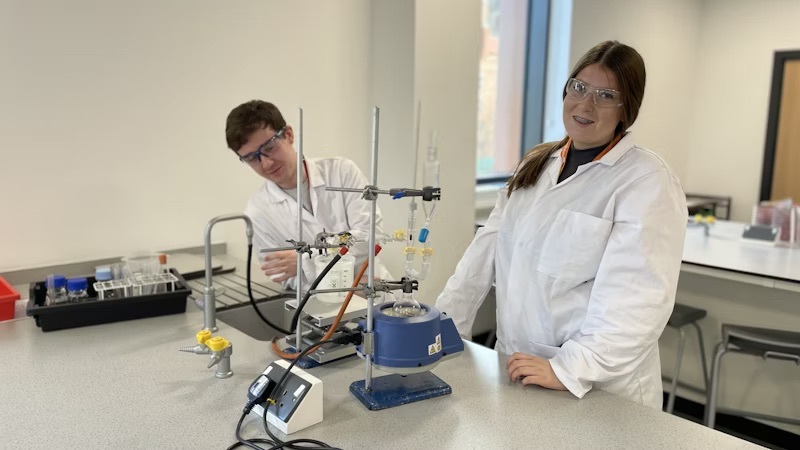 Students conducting an experiment in a science lab at the City Hub