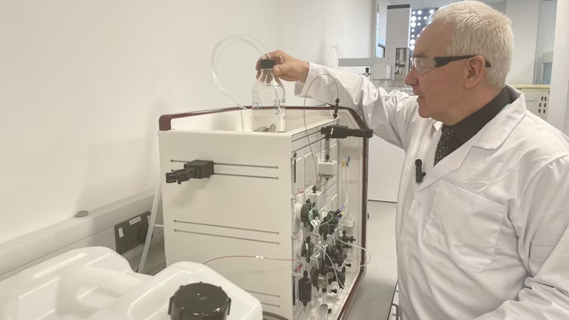 A lecturer using equipment in a science lab at the City Hub.