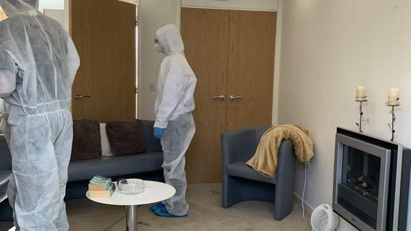 Students looking for evidence in the living room of the crime scene house.