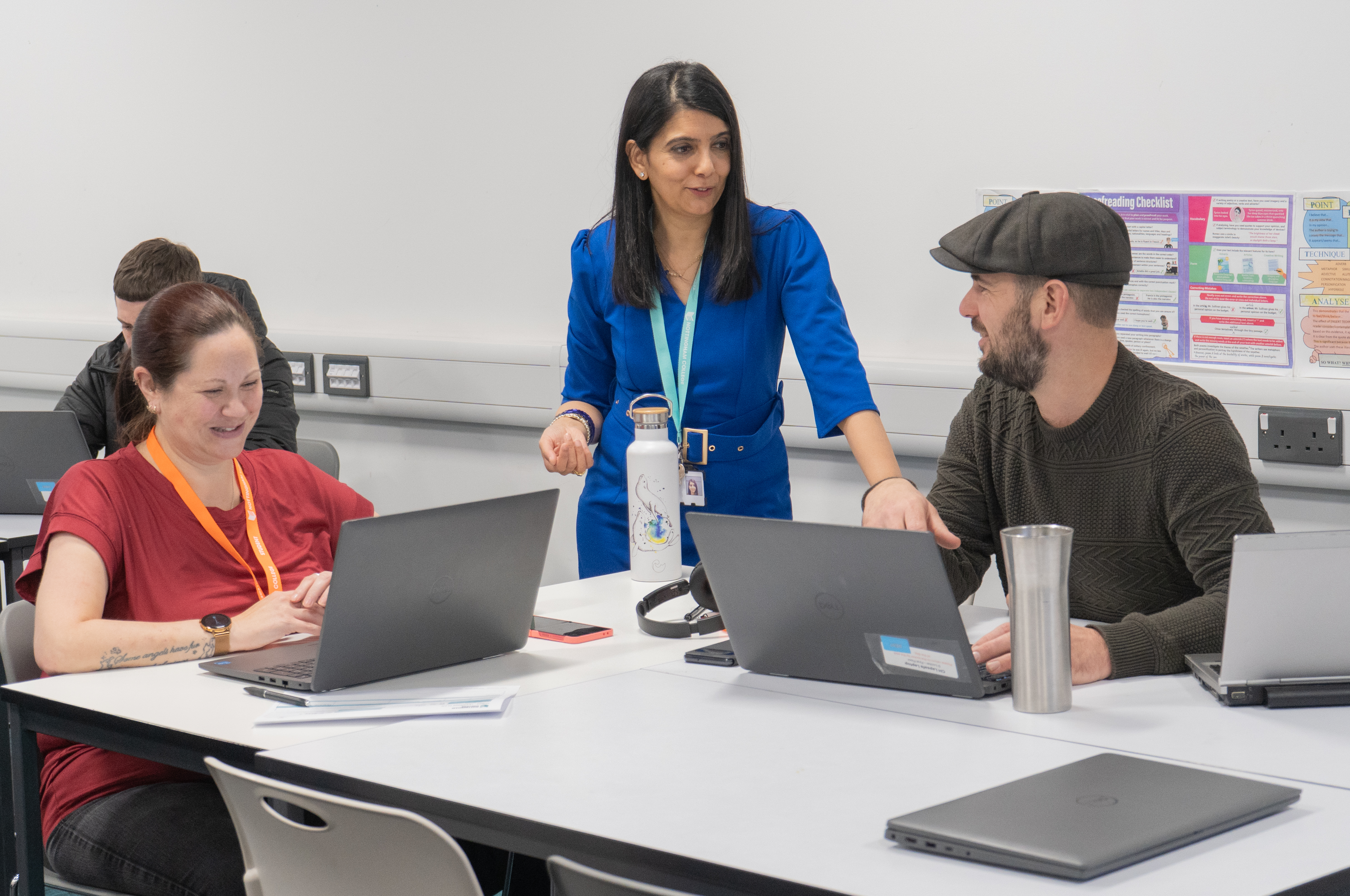 Adult students in a classroom with laptops with a lecturer