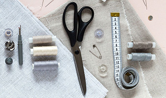 A collection of sewing accessories including scissors, thread, a tape measure and buttons