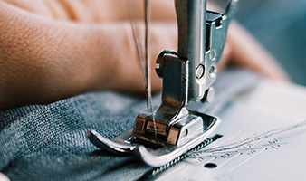 A person sewing denim with a sewing machine.