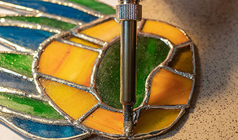 A piece of stained glass being soldered