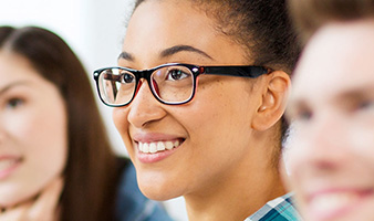 A mature student with glasses smiling