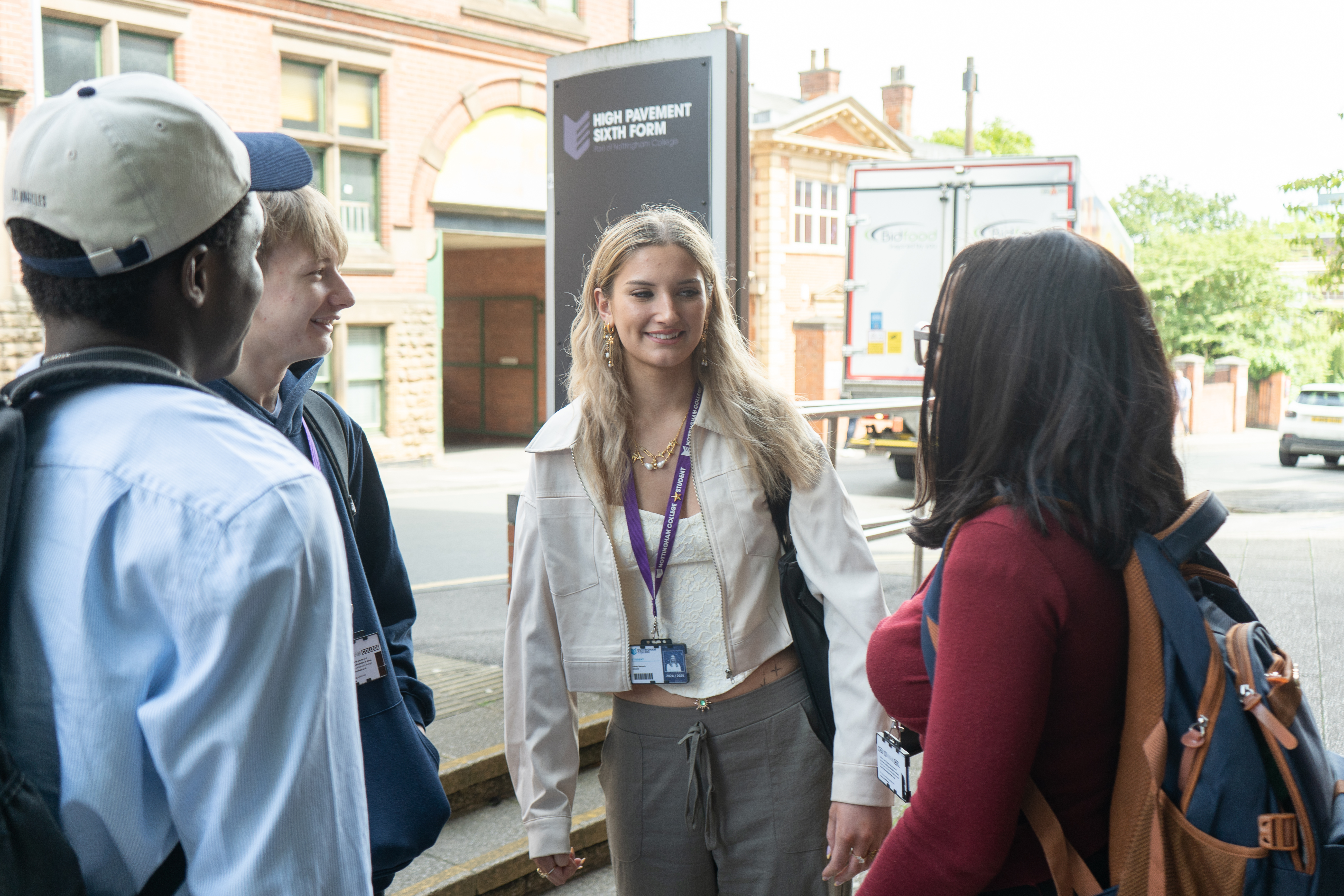 A group of four students stood in front of the High Pavement Sixth Form sign