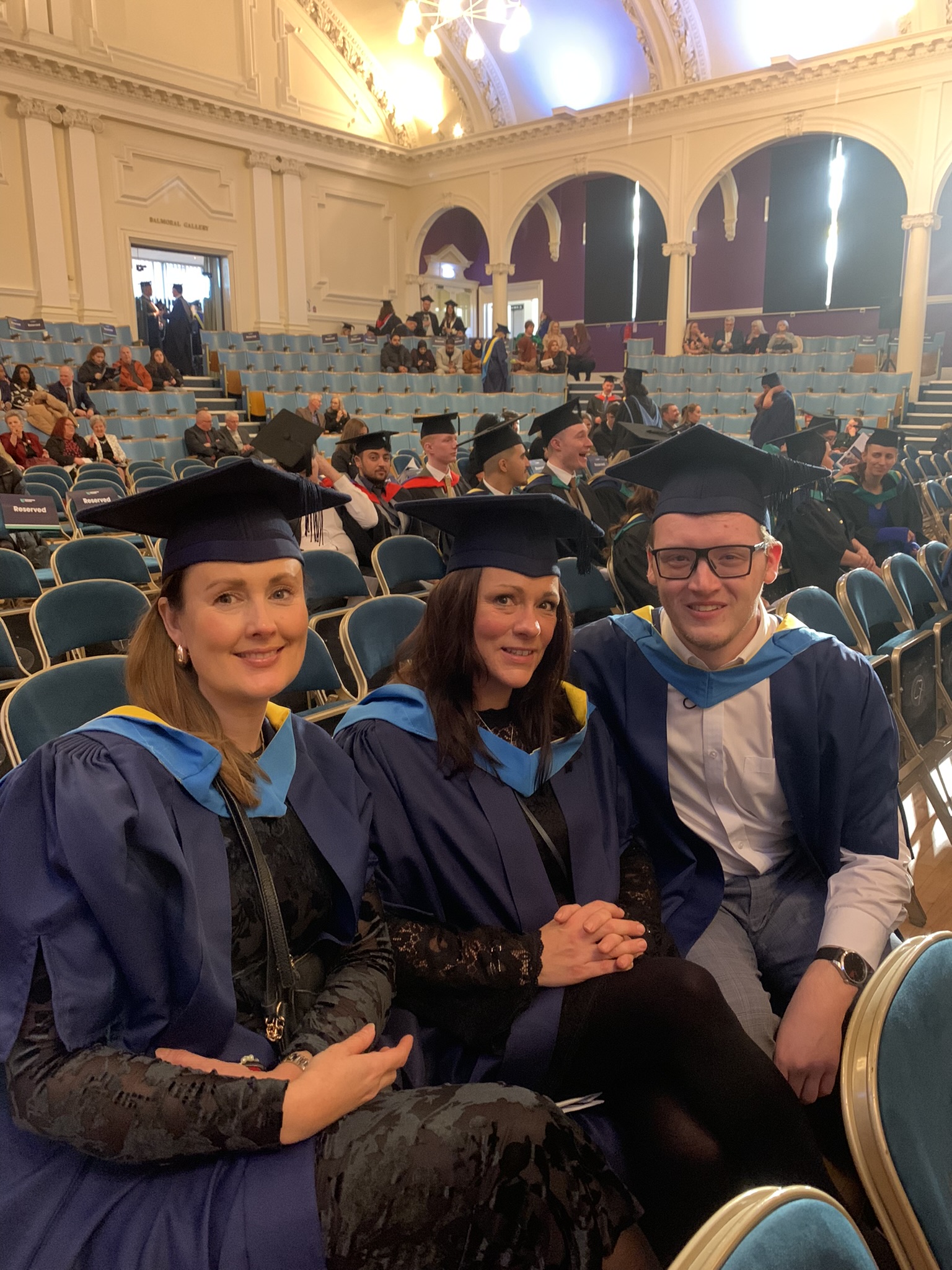 Graduates sat in the Albert Hall smiling