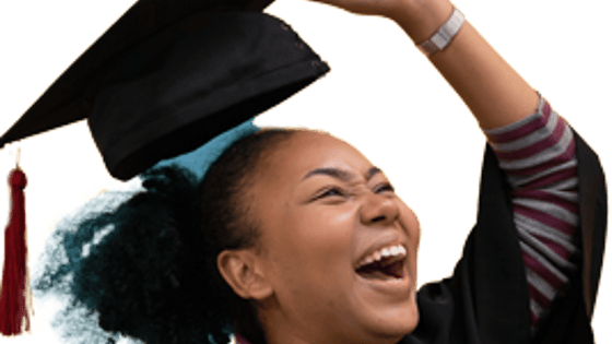 A student holding her mortar board and smiling