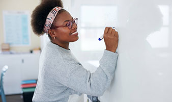 A teacher writing on a whiteboard