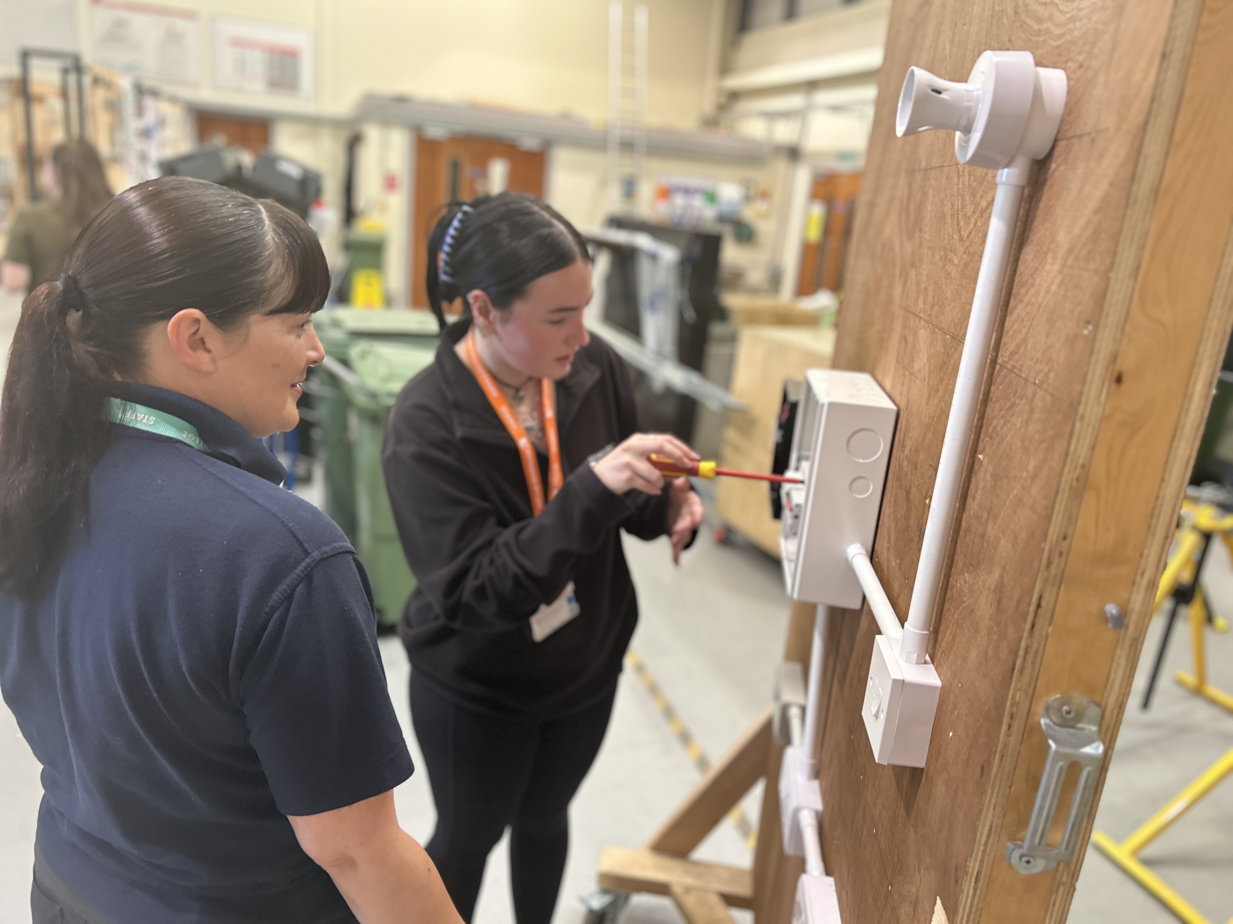 A T level engineering student working on wiring with their tutor