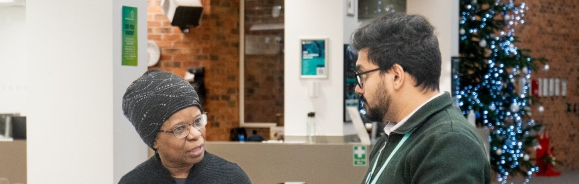 An adult learner talking to a staff member