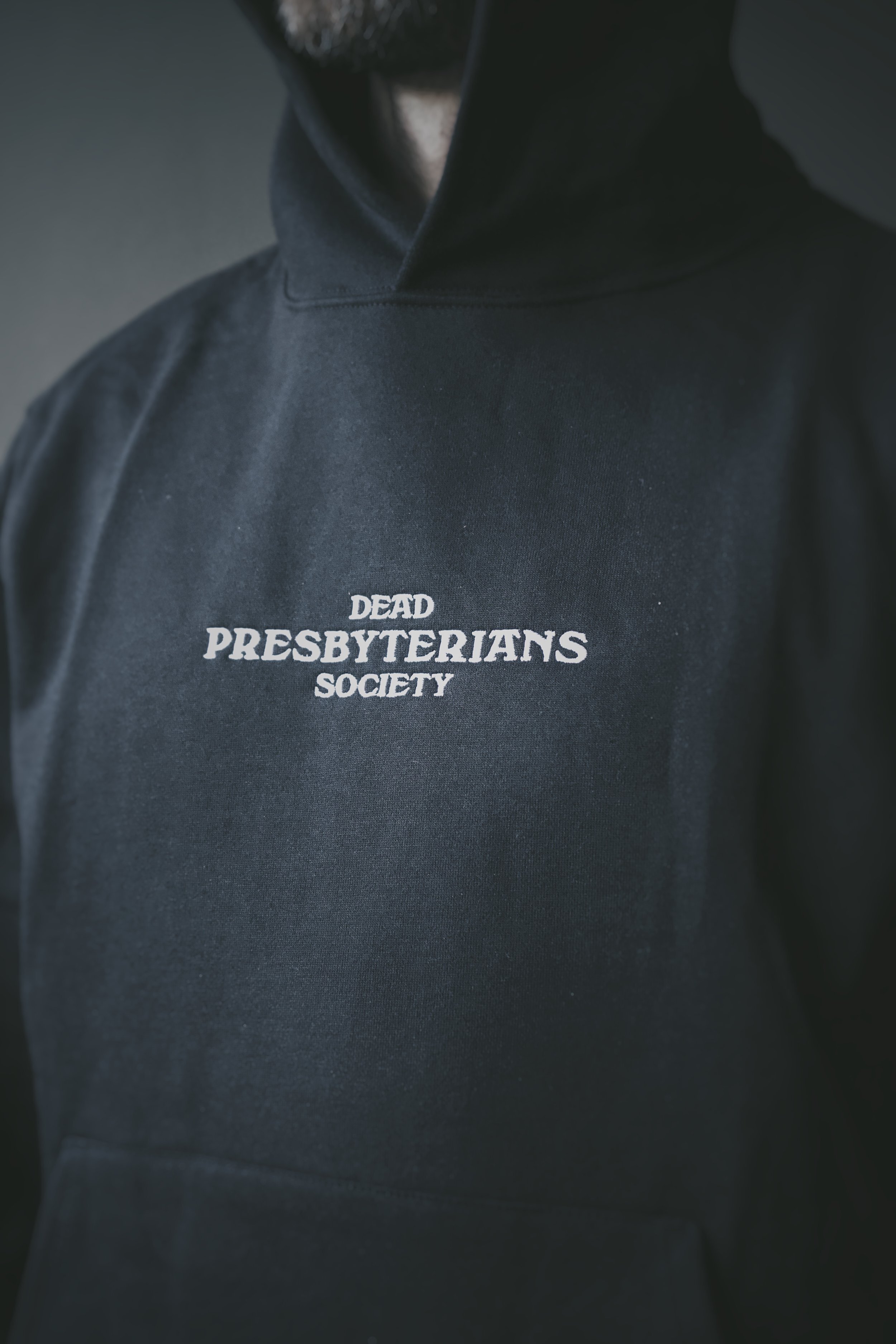 Black hoodie with the ’Dead Presbyterians Society’ logo printed on the front.
