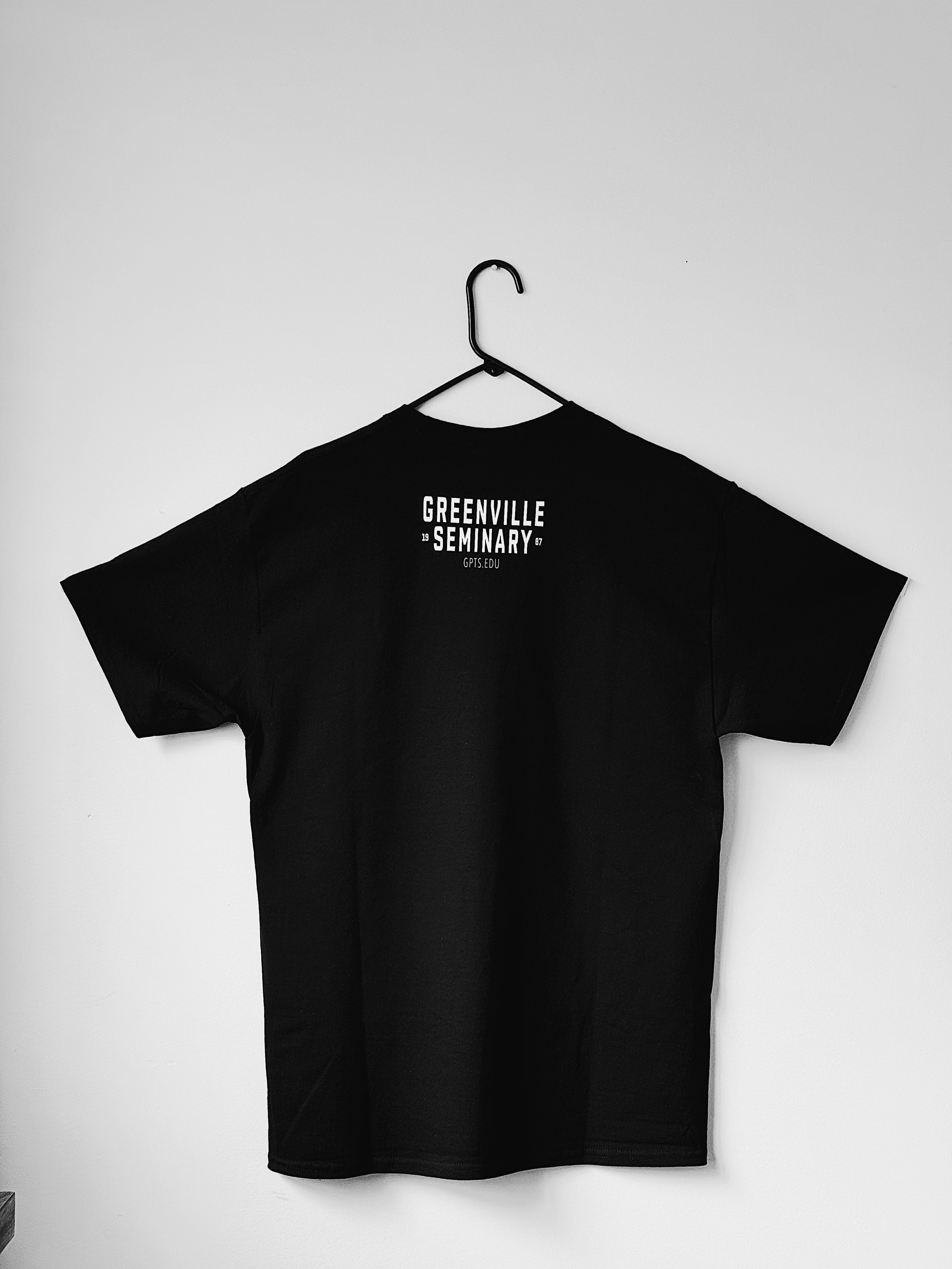 Back of a black T-shirt featuring the Greenville Seminary logo and text.