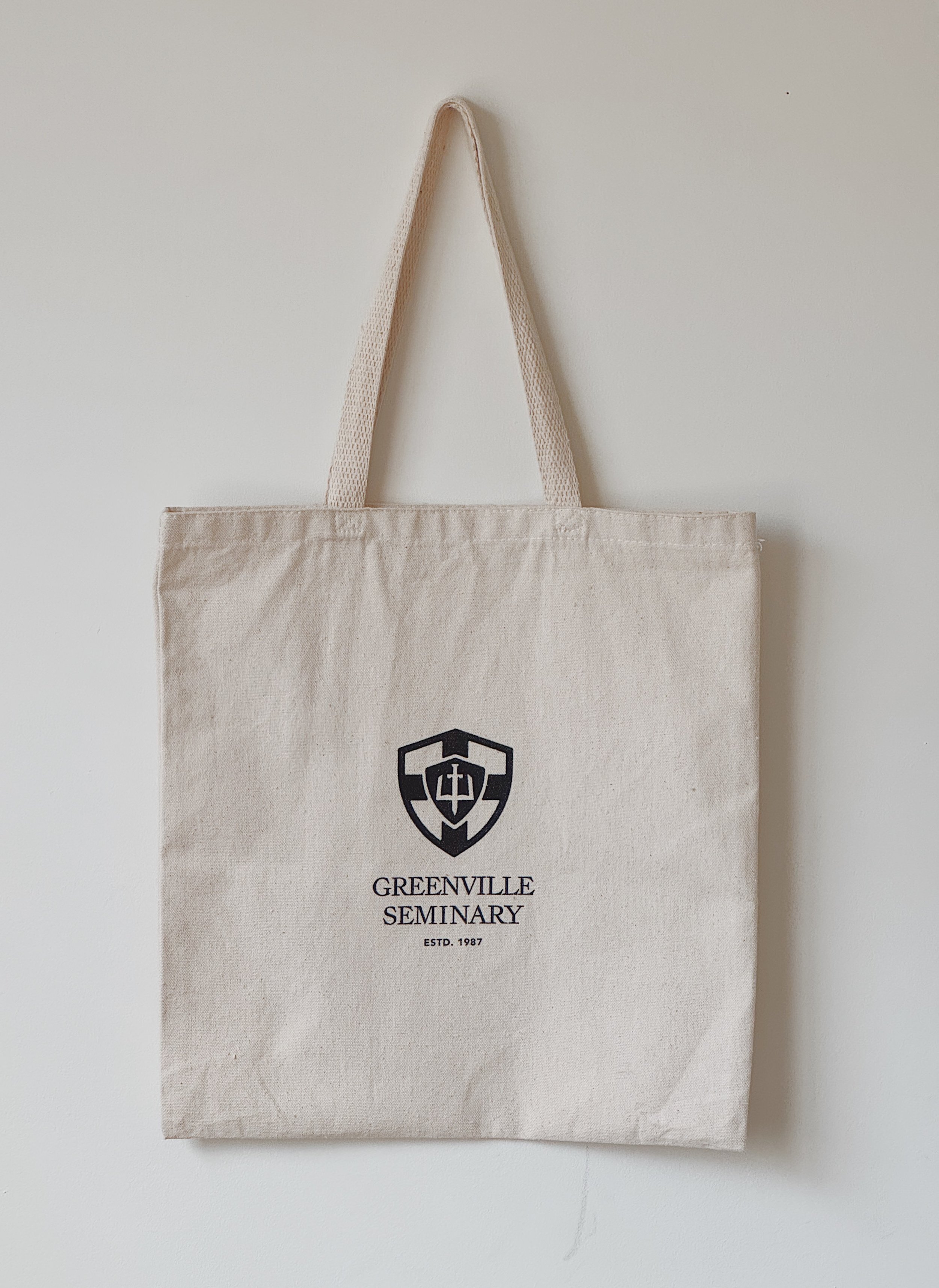 Natural canvas tote bag with the Greenville Seminary crest and text.
