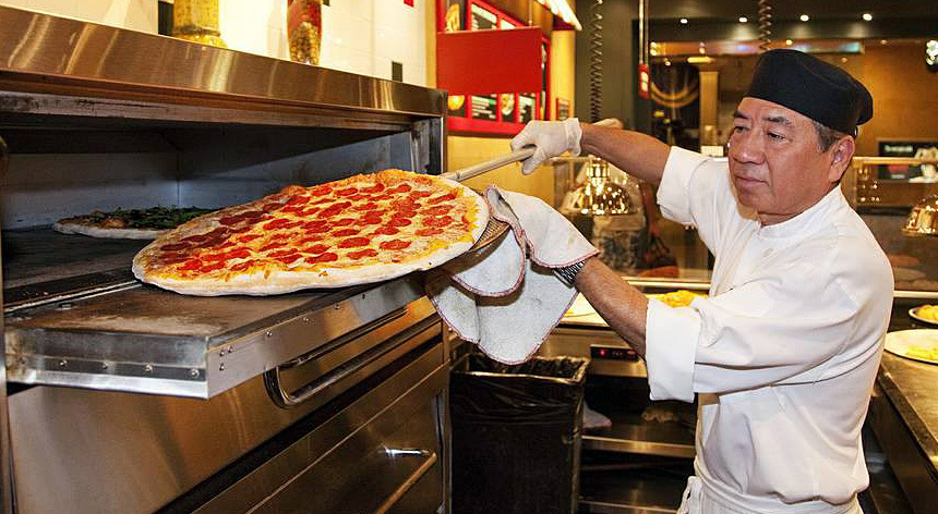 Chef taking out a pizza at Pizzeria Francescos
