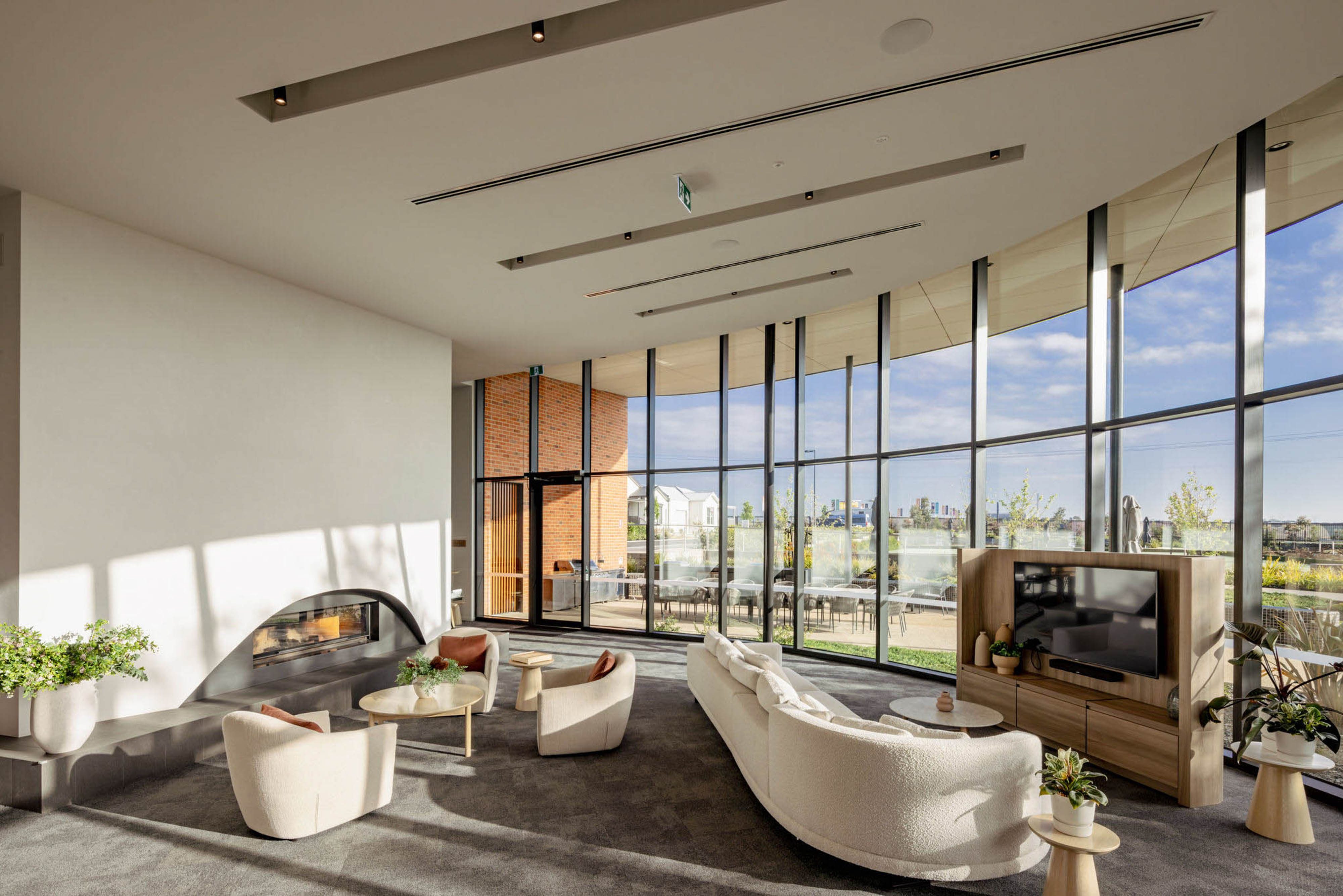 Clubhouse lounge with fireplace, seating, and large windows at Lifestyle Deanside.