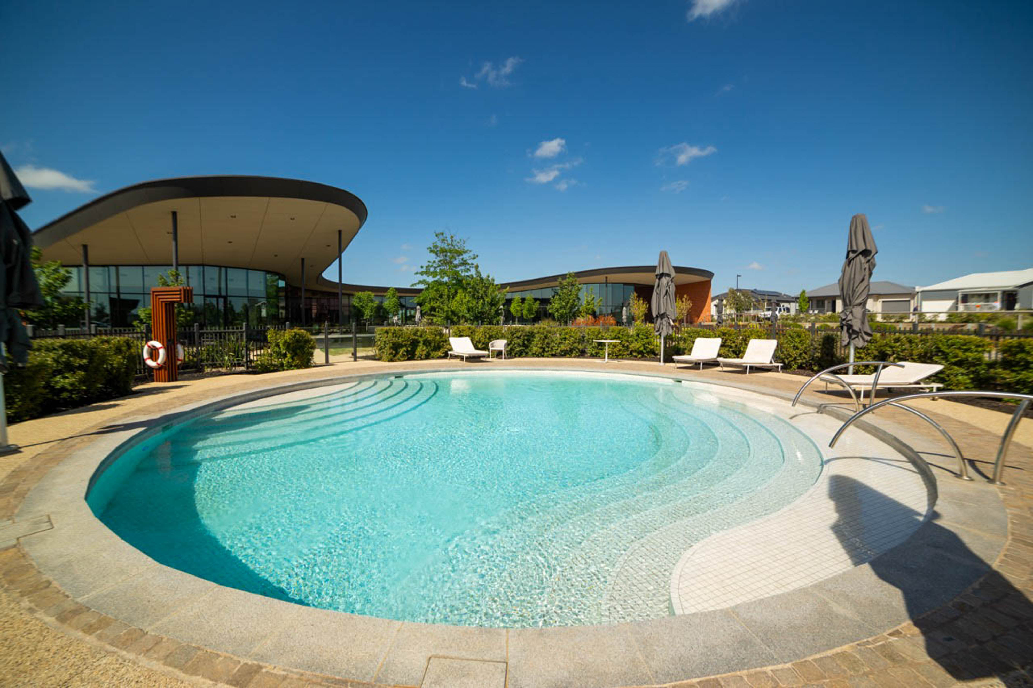 Round outdoor pool with steps and sun loungers at Lifestyle Deanside.