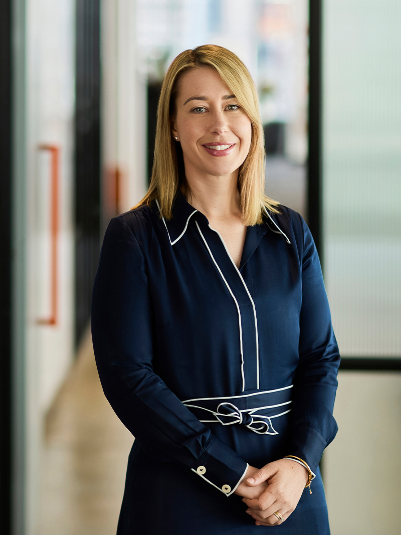 Individual wearing a navy dress with white piping detail.