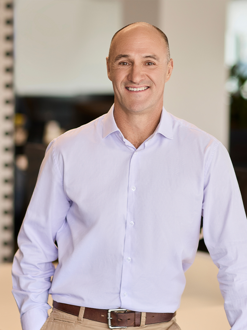 Individual wearing a light-coloured button-up shirt with a brown belt.