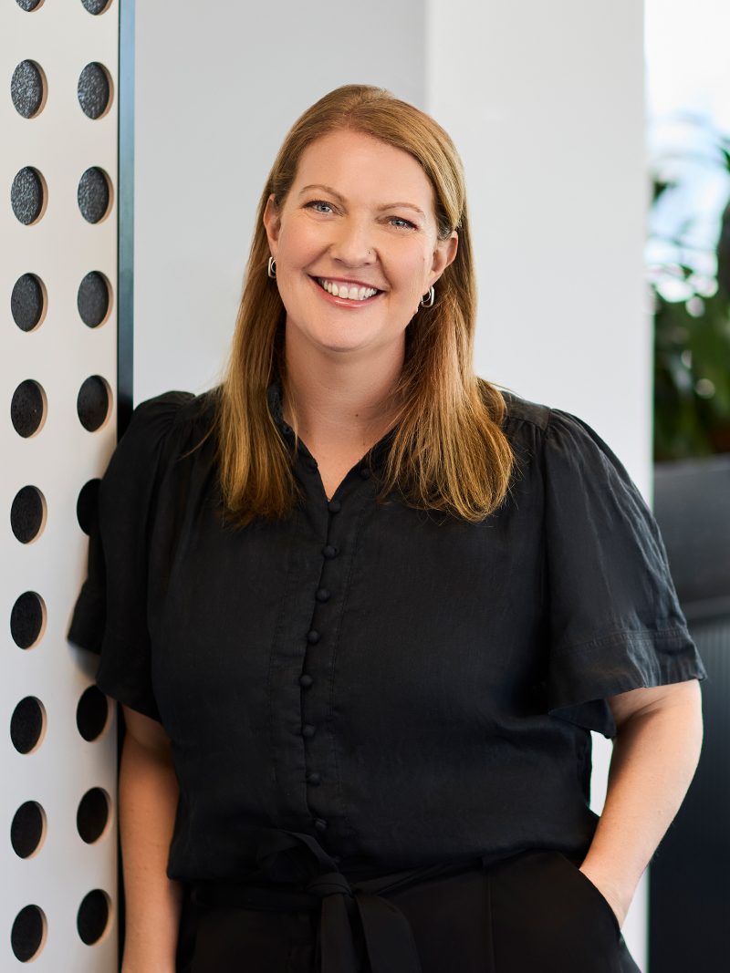 Individual wearing a black short-sleeve blouse with button-front detail.