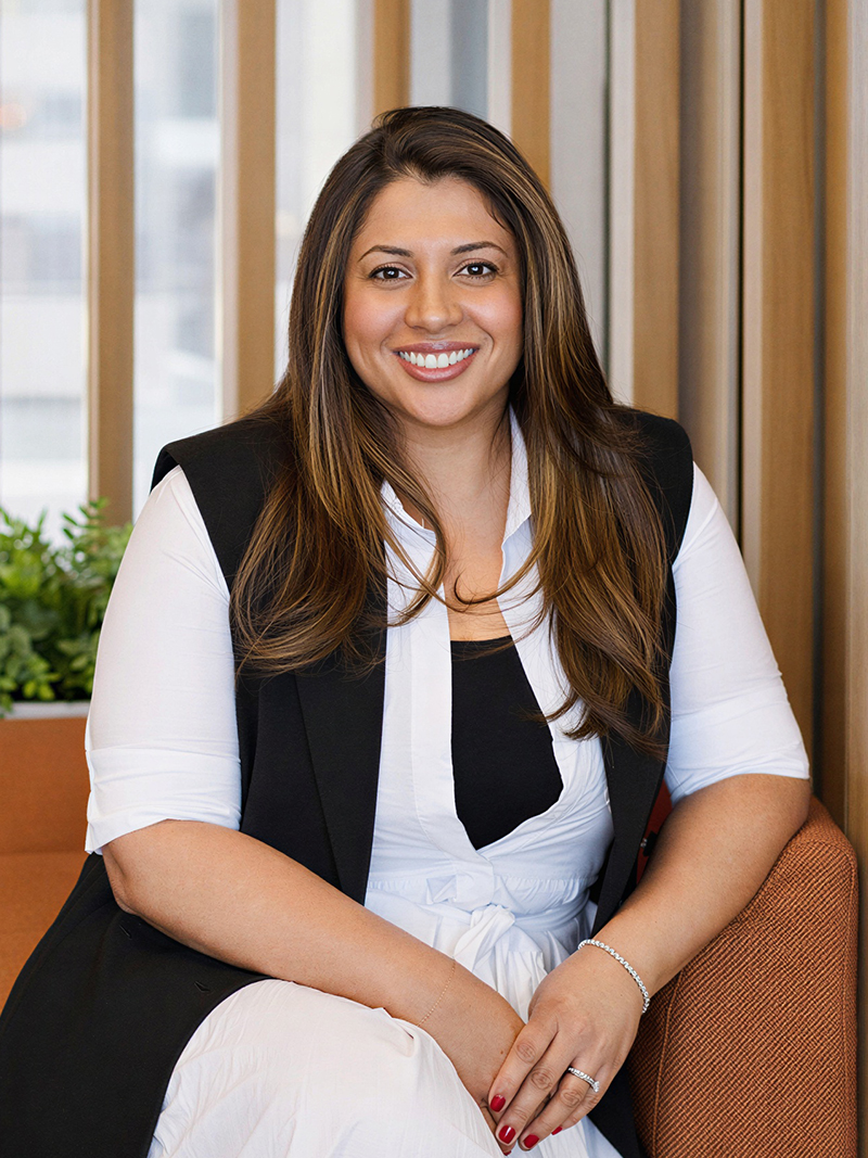 Individual wearing a white blouse with a black sleeveless vest.
