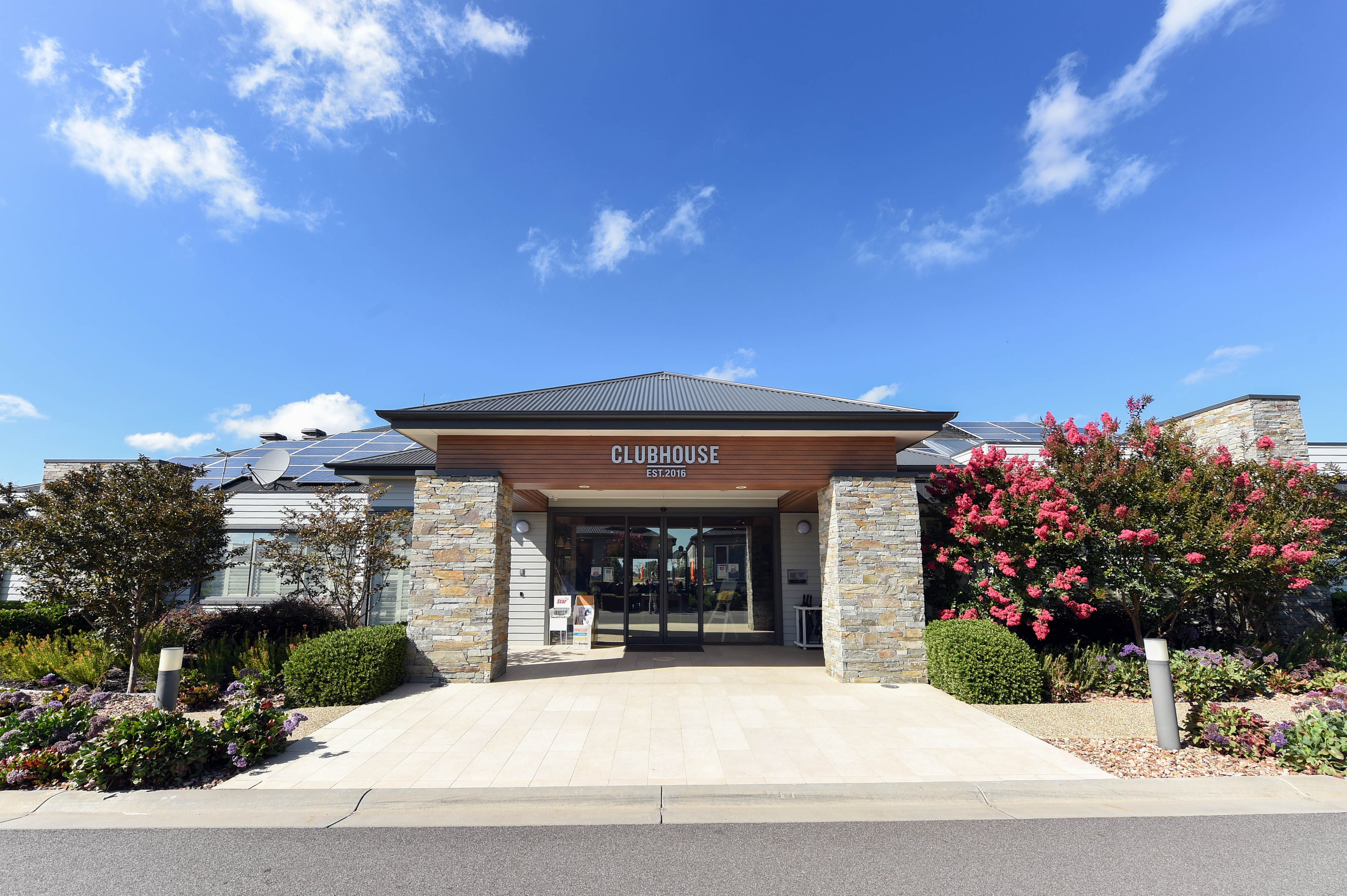Clubhouse entrance at Lifestyle Officer community with stone pillars and greenery.