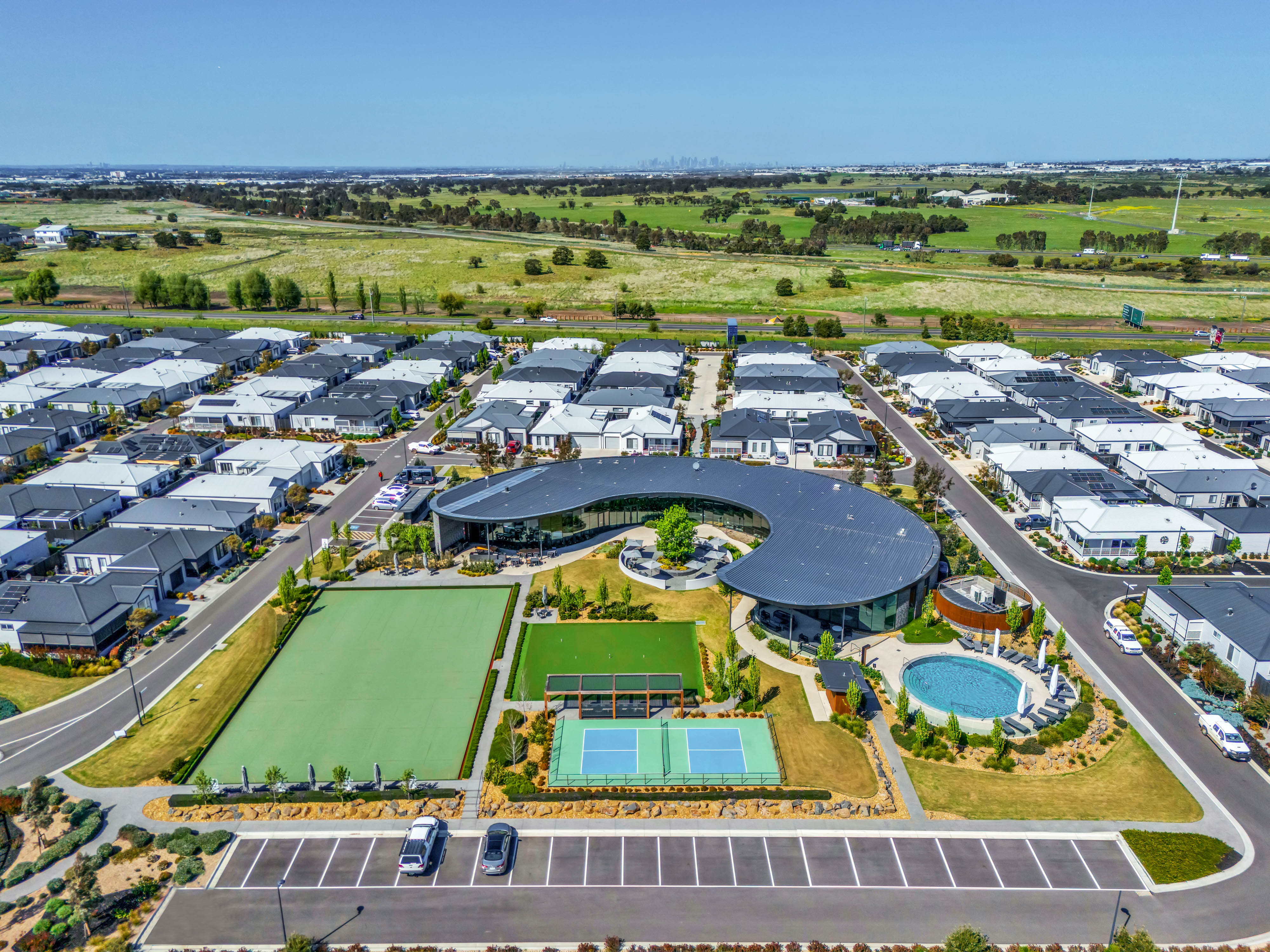 Aerial view of Lifestyle Wollert community with clubhouse, tennis courts, and landscaped gardens.