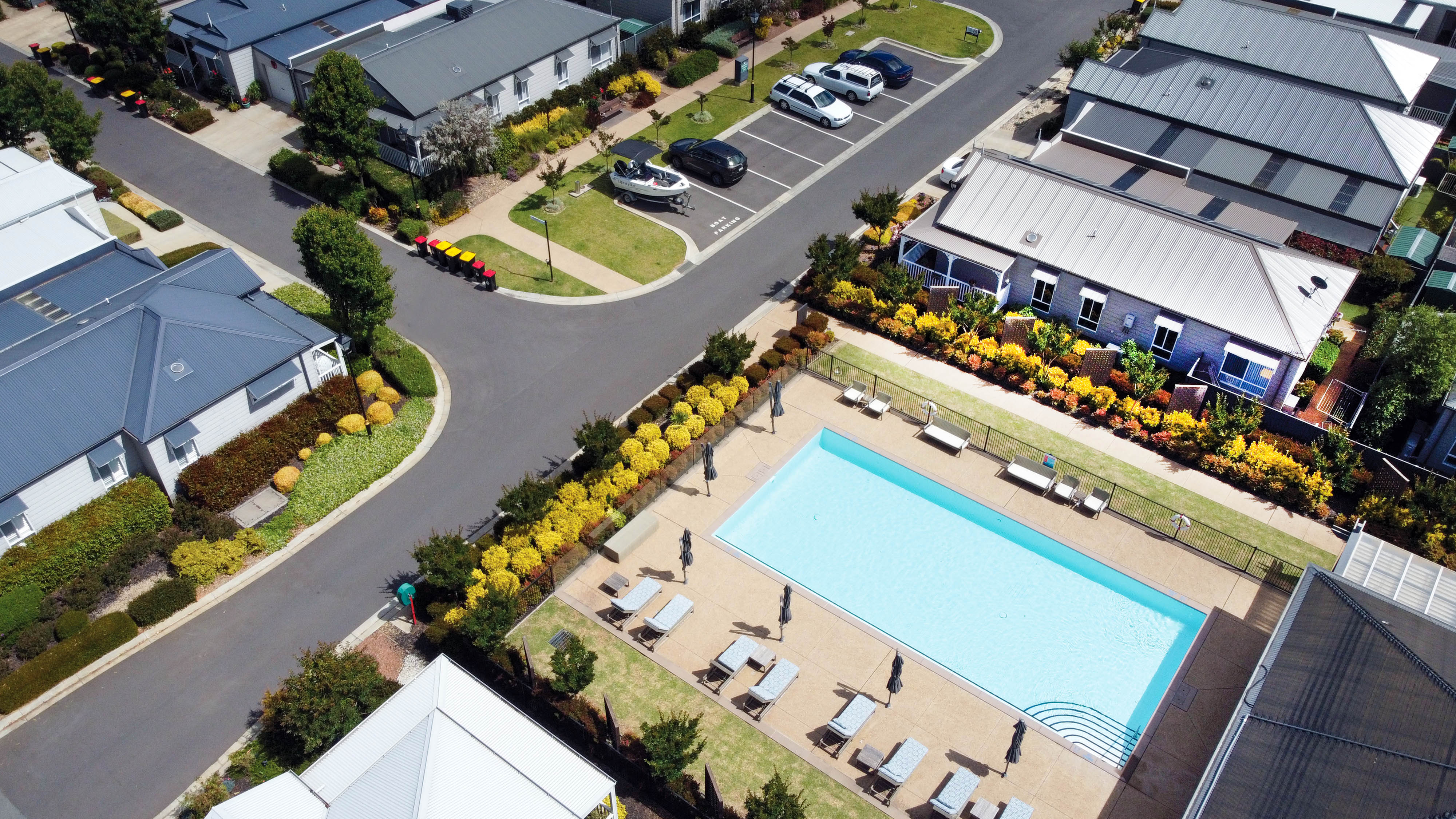 Aerial view of the outdoor pool surrounded by sun loungers and landscaped gardens at Lifestyle Shepparton.