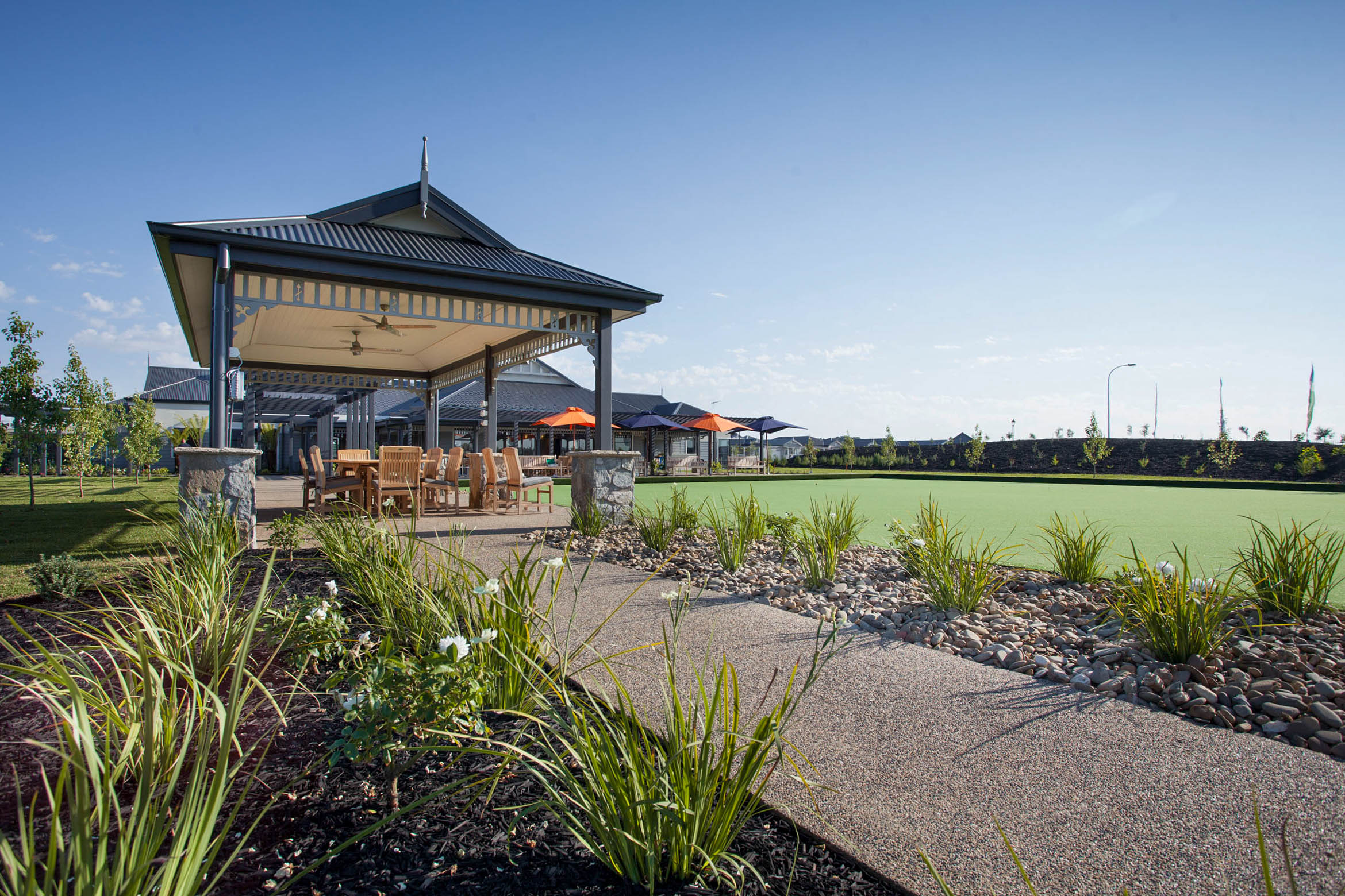 Outdoor alfresco area at Shepparton clubhouse with shaded seating and lawn bowls green.