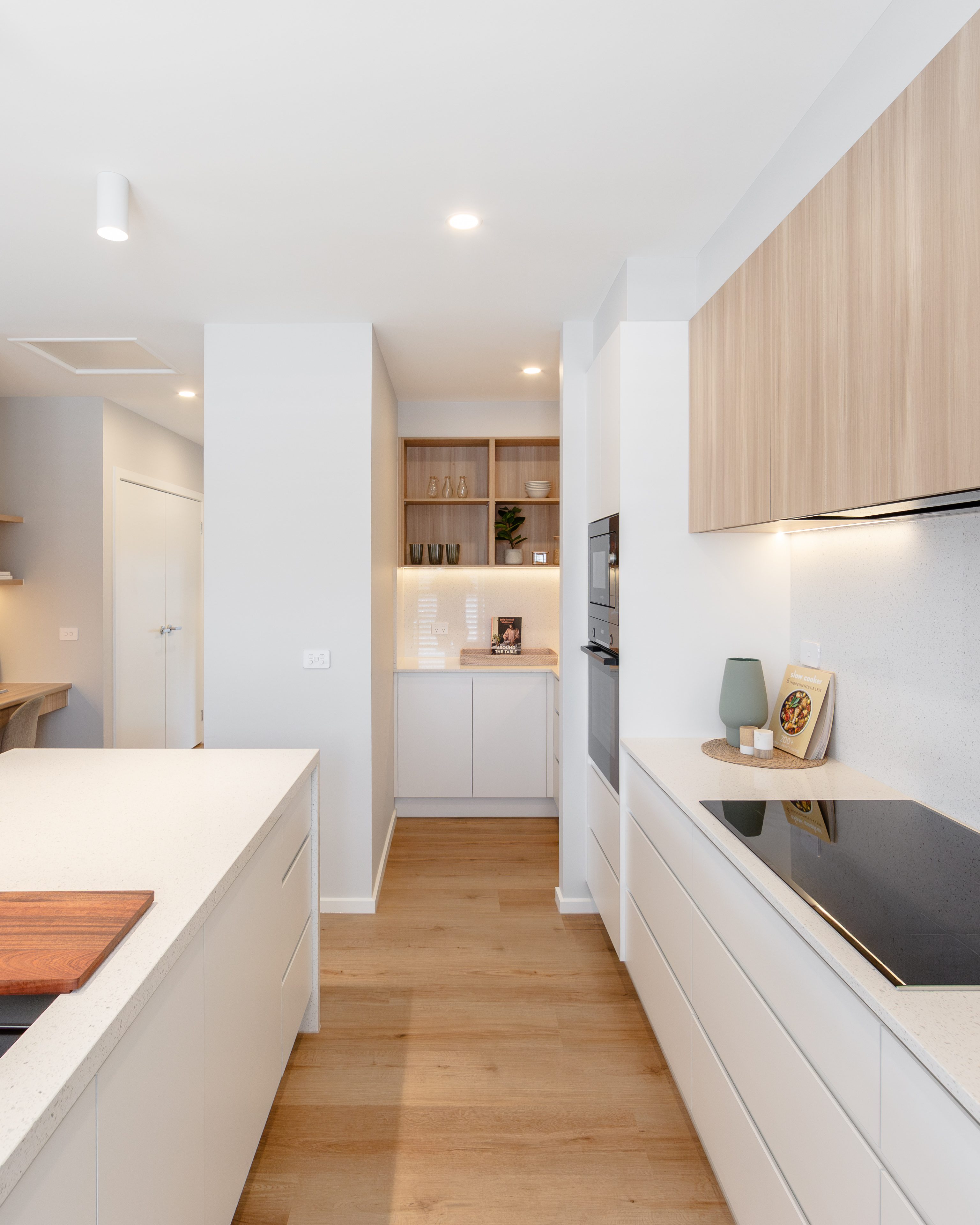 Contemporary kitchen with light wood cabinetry and modern lighting at Lifestyle The Shores.