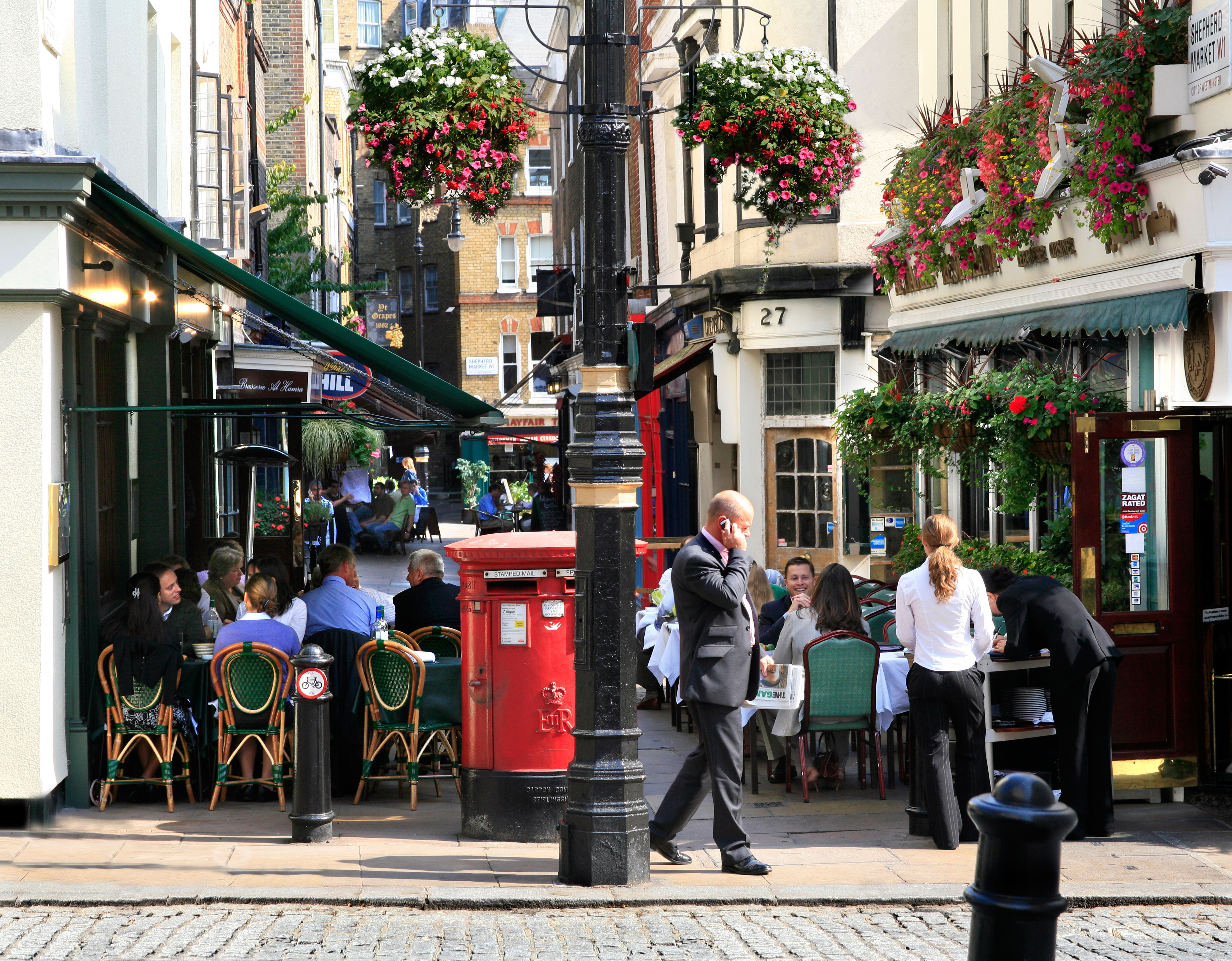 A street view in Mayfair with café and bunting overhead.