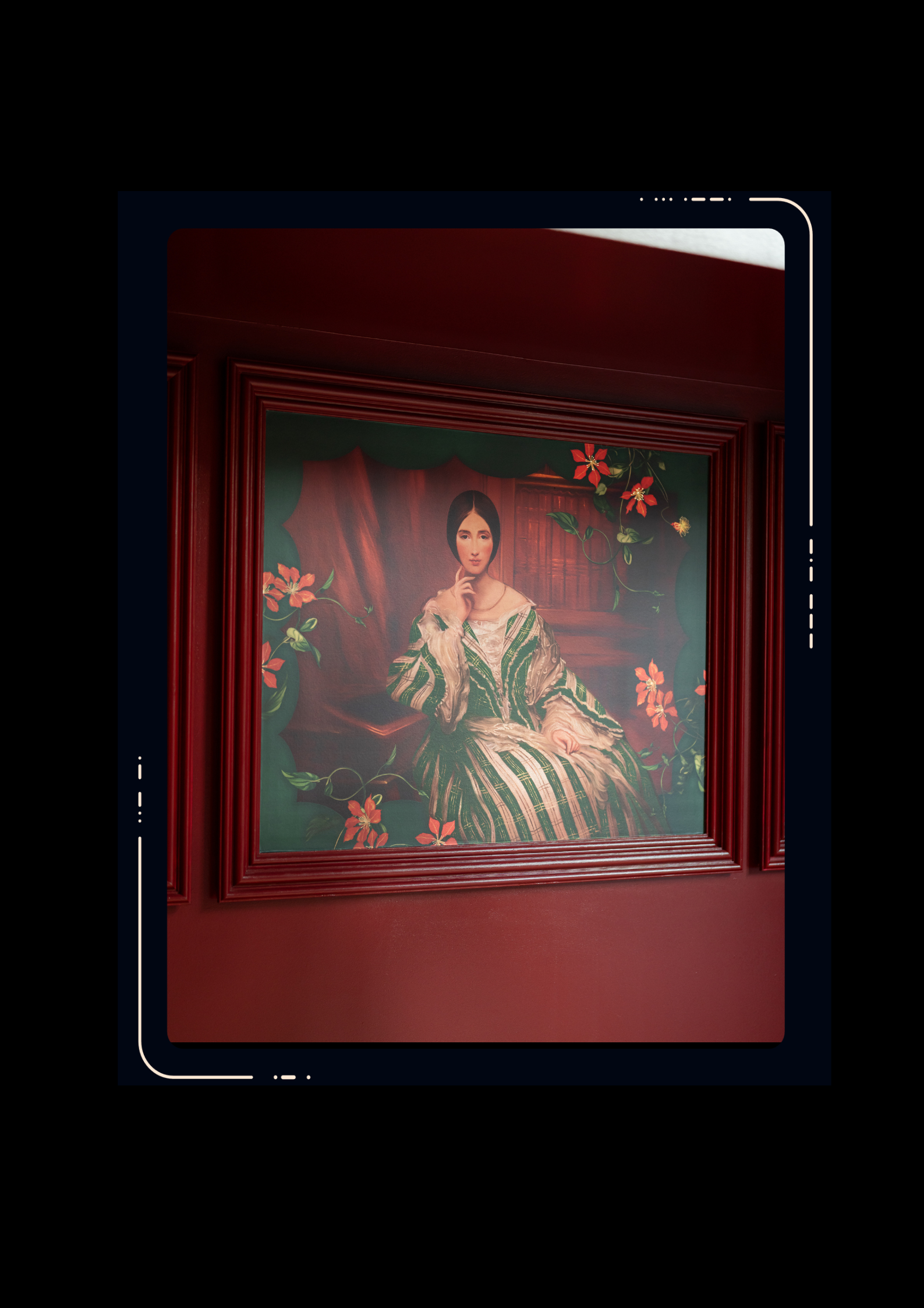 Framed portrait painting on a dark red wall showing a woman in a green and white striped dress surrounded by pink flowers and foliage.