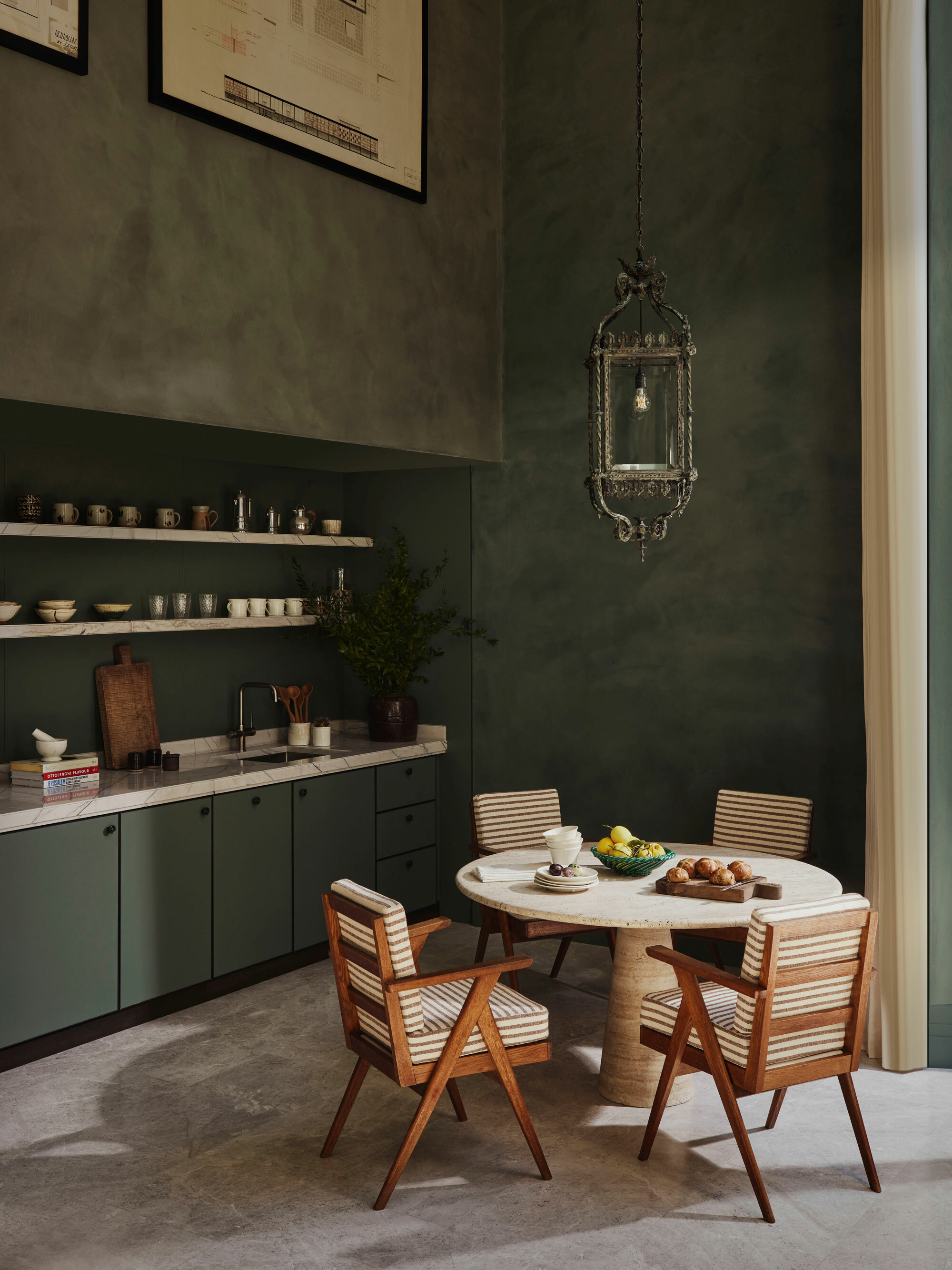 An interior with dark walls, fitted units and 4 seater dining table.