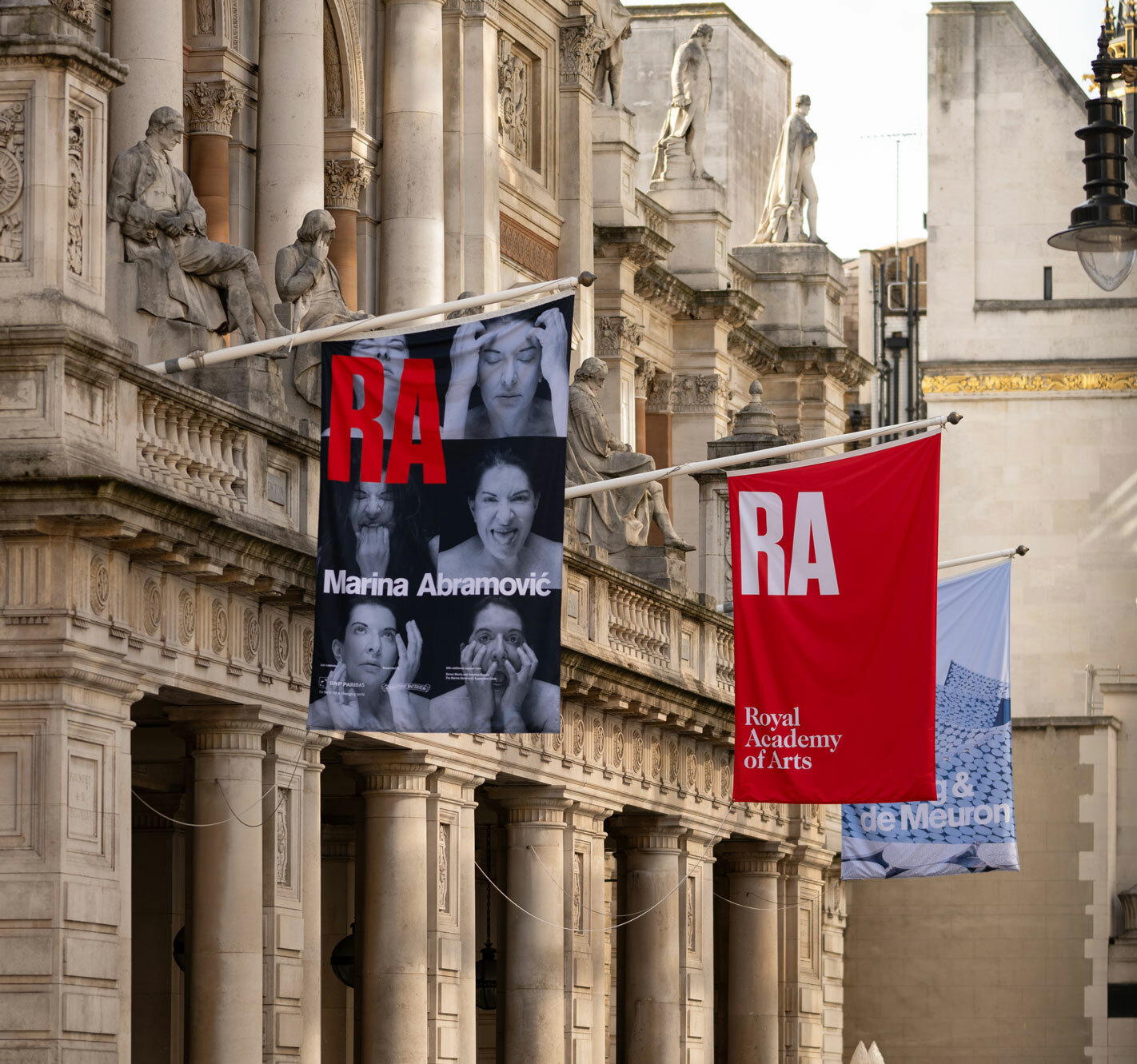 Close up side view of the Royal Academy of Arts with banner flags.