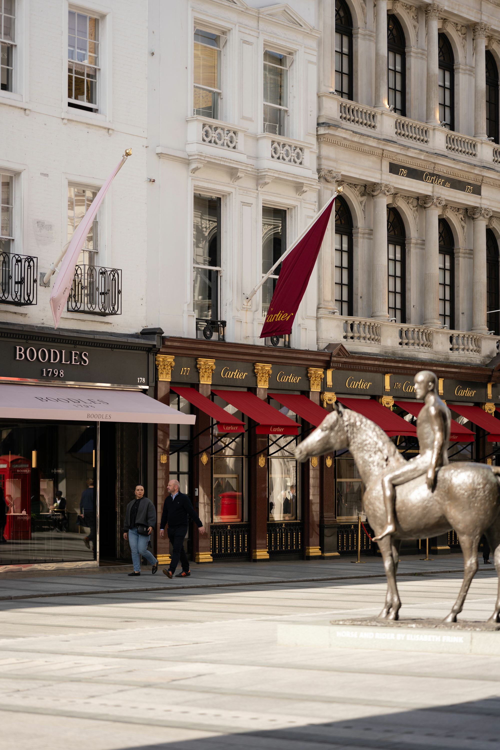 A view of New Bond Street with shops and statue of horse and rider.