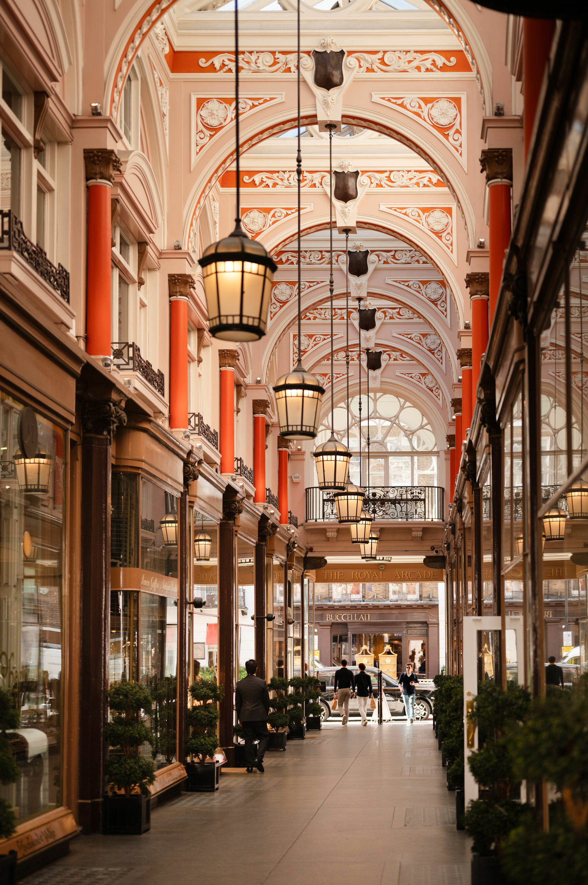 A view of a shopping arcade in London, with large ceiling light features and .egal decor,
