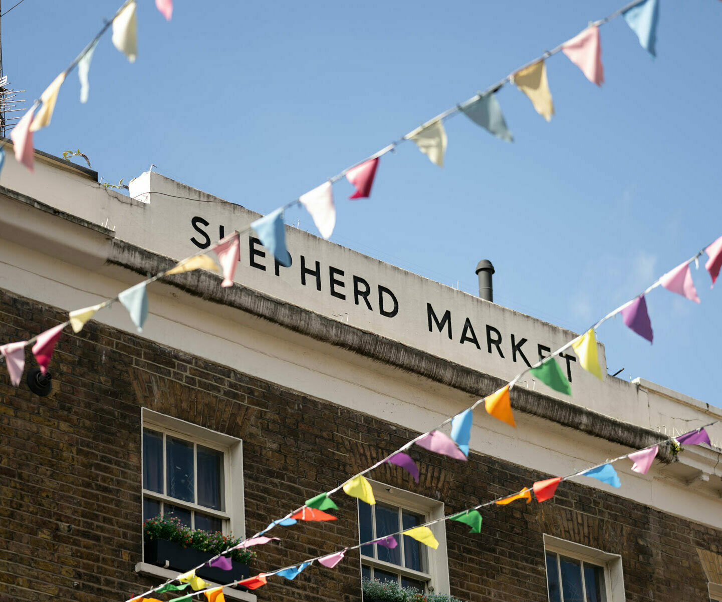 A zoom in view of Shepherd Market with bunting overhead.