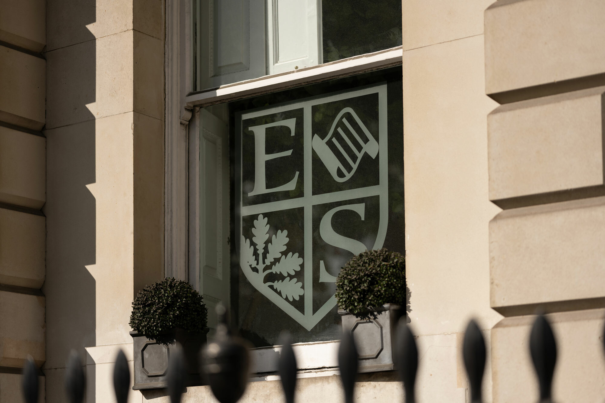 Close up of school window with vinyl Eaton Square Senior School logo.