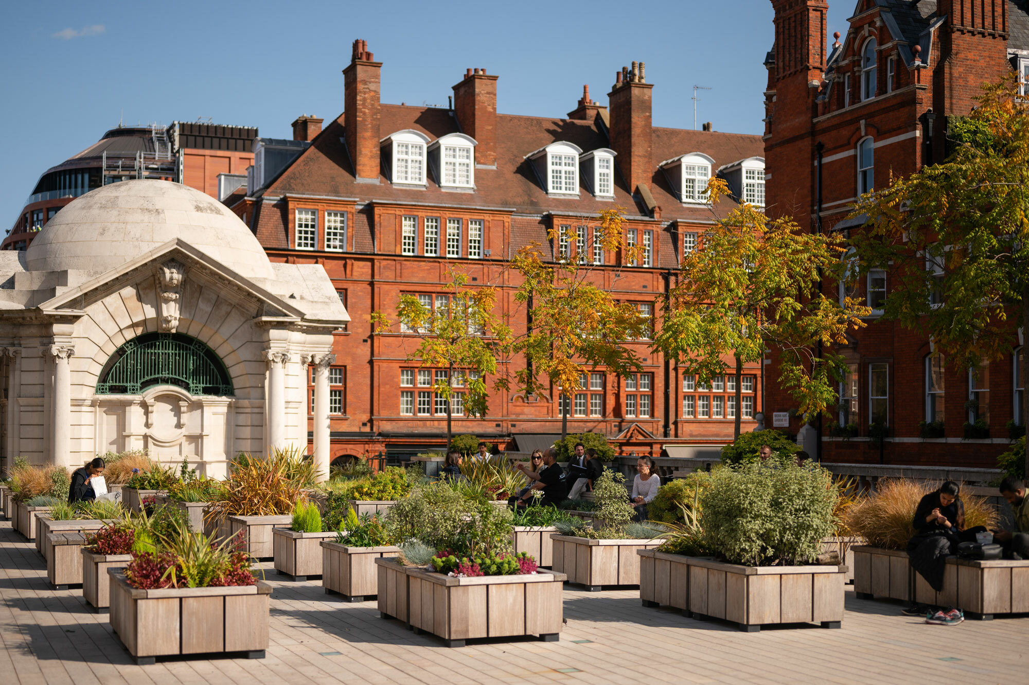 Raised terraced garden in Mayfair with red brick building in background.