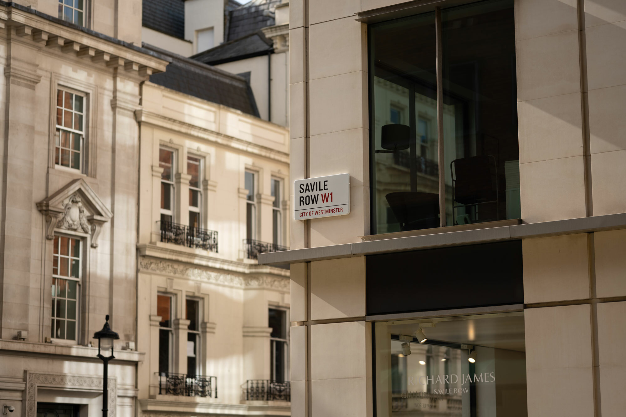 A close view of Saville Row street sign on the side of a building.
