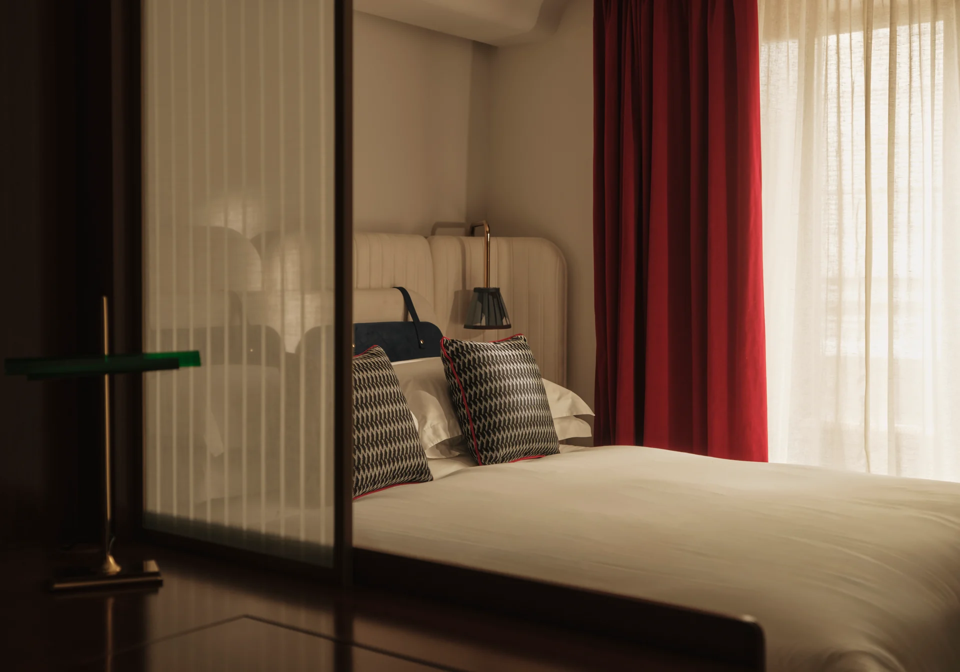 Chambre du Shepherd Mayfair avec rideau rouge et coussins à chevrons