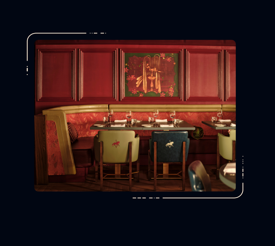 Restaurant dining area with red panelled walls, curved banquette seating, mixed leather chairs with embroidered motifs, set tables and artwork above.