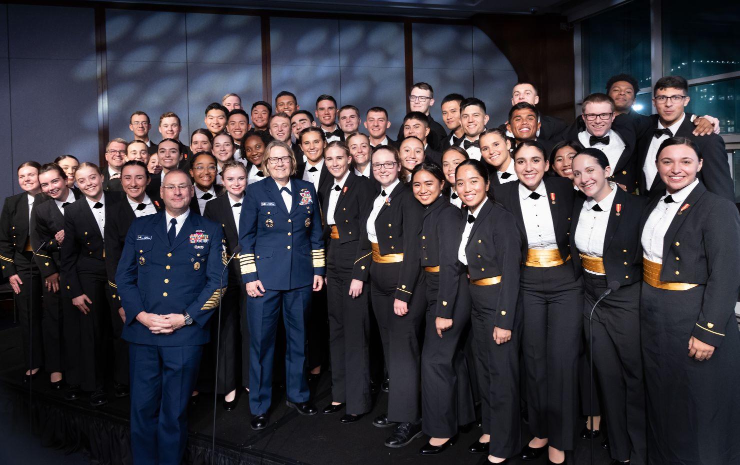 Group photo of Coast Guard Academy cadets and Coast Guard leaders on a riser.