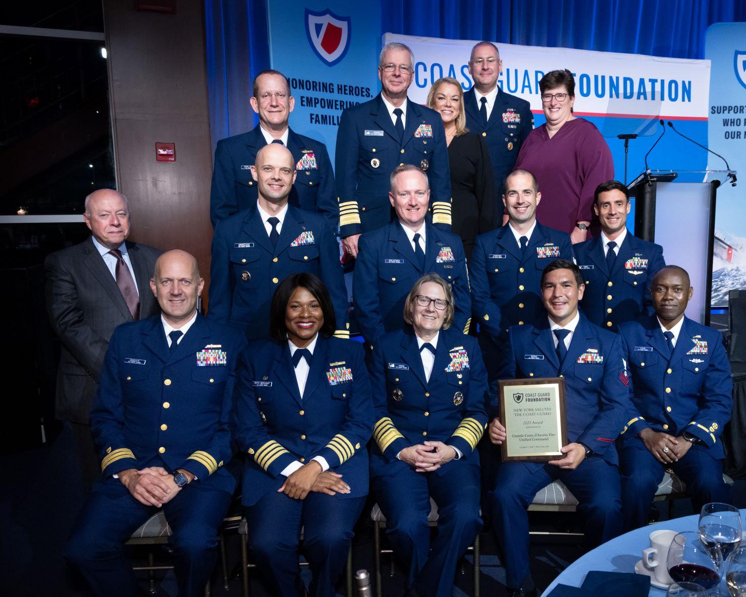 Coast Guard members seated with an award