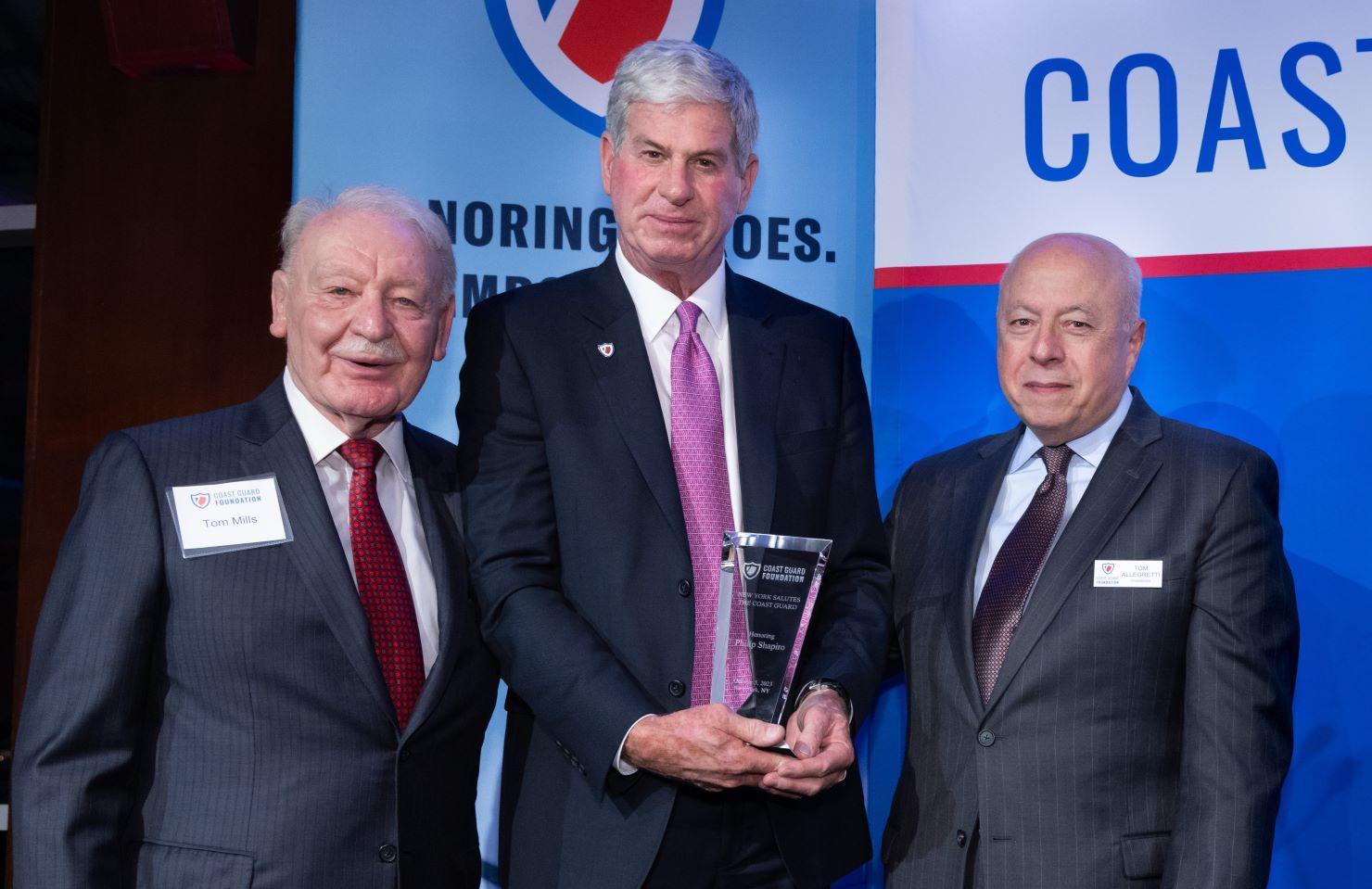 3 men posing with an award