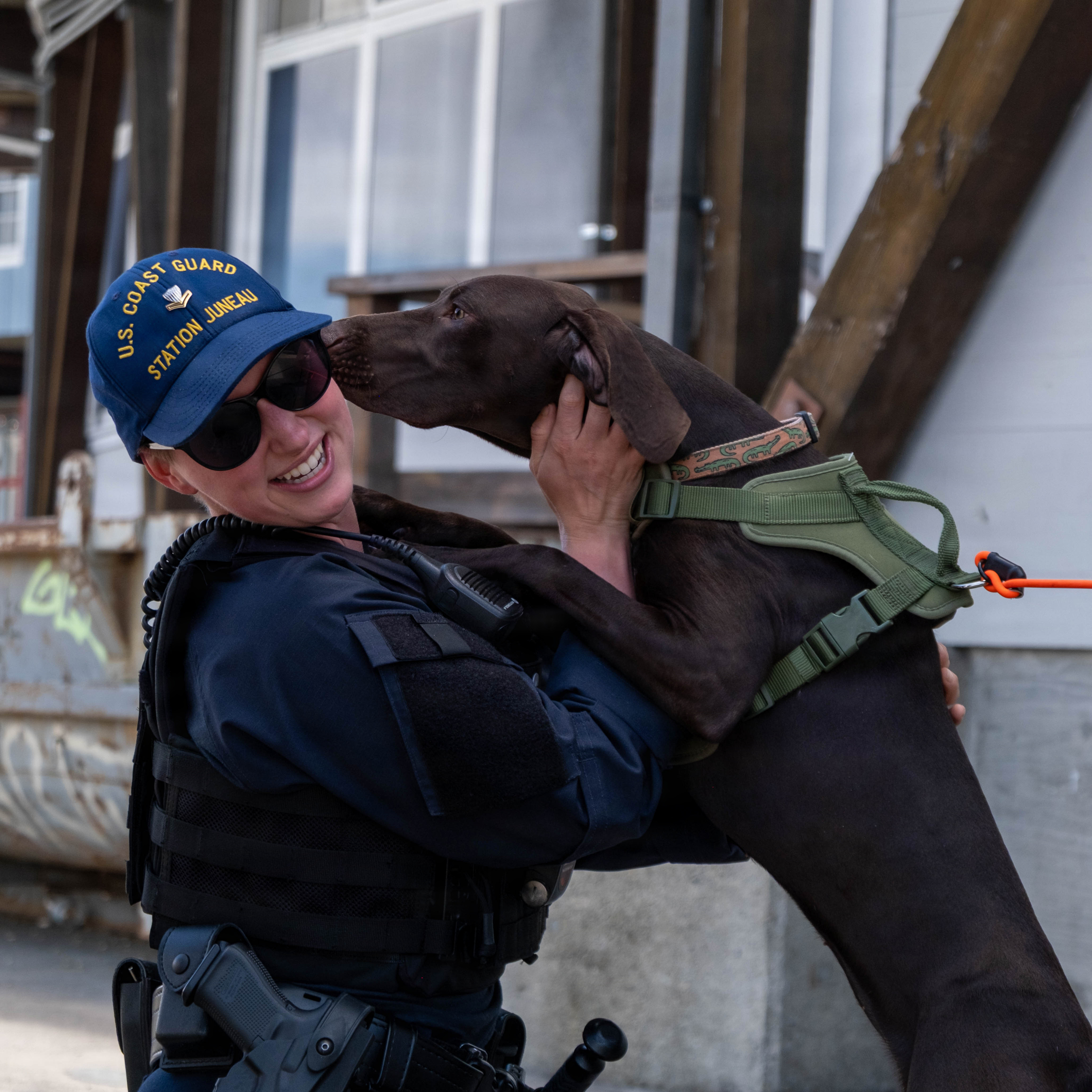 Coast Guard petty officer interacts with a dog near Pier 39 in San Francisco during FIFA World Cup 2026 community engagement.