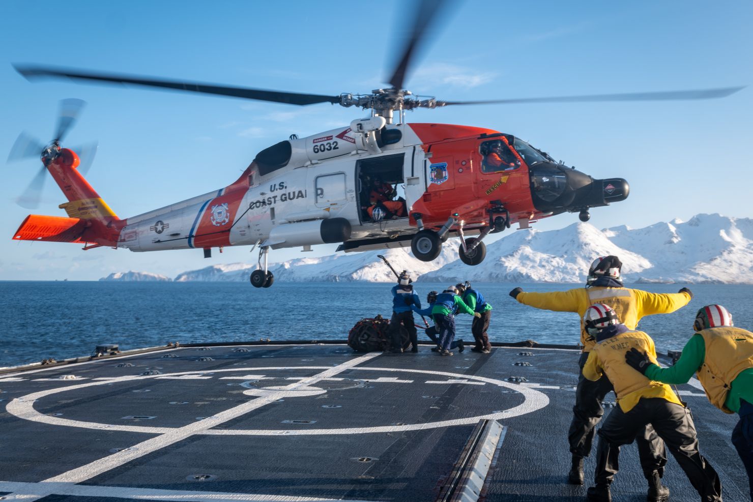 Helicopter hovering over a ship's deck.