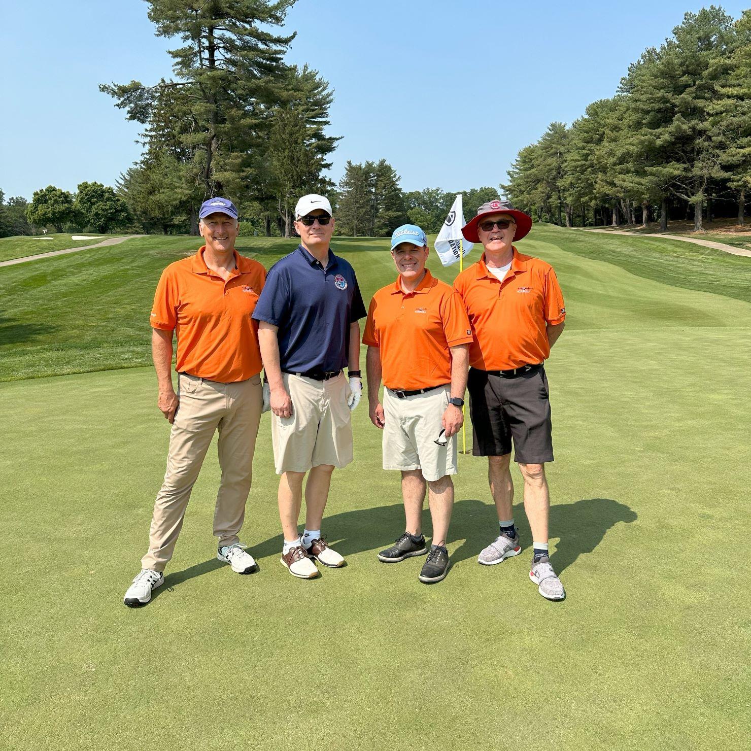 Four men standing on a golf course