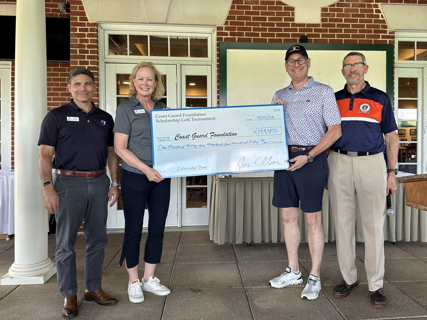 A group pose with a big check.